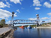 Судно обеспечения нефтяных платформ "ФД Анбитбл" с буксирами "Барс" и "ОТА-990" под разведённым Подпорожским мостом через реку Свирь