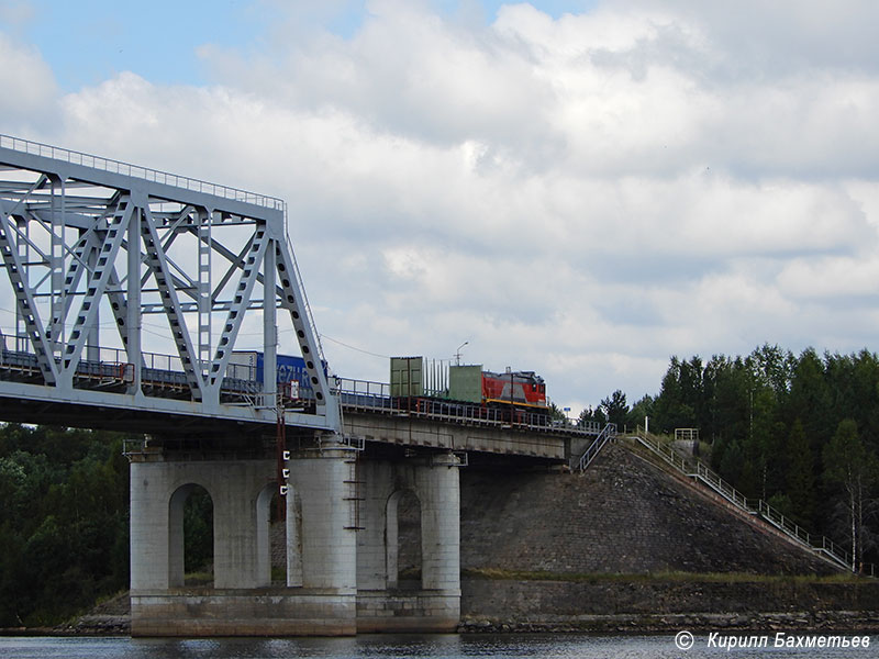 Тепловоз ТЭМ18ДМ с вагоном для перевозки леса на Лодейнопольском мосту через Свирь